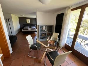 a living room with a bed and a table and chairs at Small Green Views in Contra