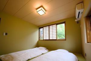 a small room with a bed and a window at 康郷 箱根湯本 in Wada