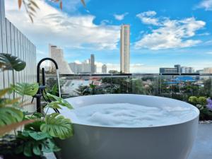 a bath tub with a view of a city at HT9 Hotel in Jomtien Beach