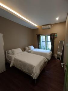 une chambre d'hôtel avec deux lits et une fenêtre dans l'établissement Villa Vigga Sanur, à anur