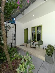 une terrasse avec 2 chaises et une table sur une maison dans l'établissement Villa Vigga Sanur, à anur