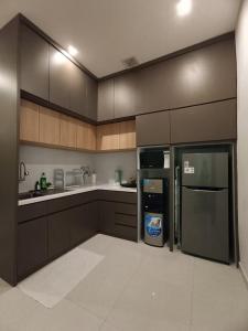 une cuisine avec des armoires en bois et un réfrigérateur en acier inoxydable dans l'établissement Villa Vigga Sanur, à anur