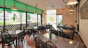 ein Esszimmer mit Tischen und Stühlen und Fenstern in der Unterkunft Hotel Keifuku Fukui Ekimae in Fukui + 91 Fotos