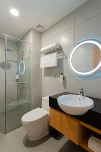 a bathroom with a sink and a toilet and a mirror at Bcons City Hotel in Dĩ An