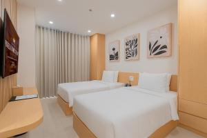 a hotel room with two beds and a flat screen tv at Bcons City Hotel in Dĩ An +95 photos