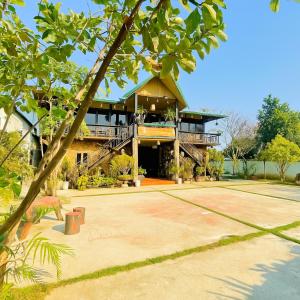 a large house with a large patio in front of it at Hải Long Homestay in Làng Chan Han