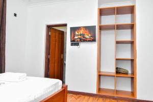 a bedroom with a bed and a book shelf at Monalisa Studio Apartments in Gatunga