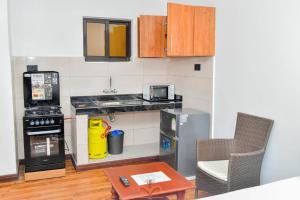 a small kitchen with a stove and a microwave at Monalisa Studio Apartments in Gatunga