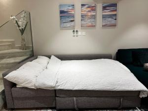 a bed in a bedroom with three pictures on the wall at Beiruty House -Elegant Family Seaside Villa in As Sīfah +13 photos