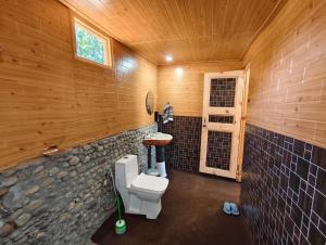 ein Badezimmer mit Toilette und Steinwand in der Unterkunft Outback Cottages and Camps in Saturang