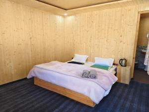 ein Schlafzimmer mit einem Bett mit zwei Hausschuhen darauf in der Unterkunft Outback Cottages and Camps in Saturang