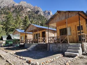 eine Gruppe von Gebäuden mit Bergen im Hintergrund in der Unterkunft Outback Cottages and Camps in Saturang