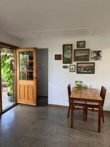 a dining room with a wooden table and a door at Lower Mountains Retreat in Warrimoo +16 photos