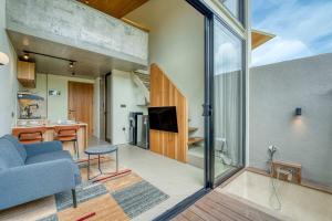 un salon avec un canapé bleu et une cuisine dans l'établissement Bingo Bingin Cozy 1BR Townhouse Nearby Bingin Beach, à Bingin Beach