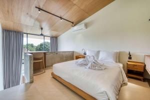 une chambre avec un grand lit blanc et un bureau dans l'établissement Bingo Bingin Cozy 1BR Townhouse Nearby Bingin Beach, à Bingin Beach 10 autres photos