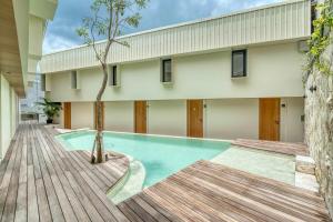 une piscine avec un arbre en face d'un bâtiment dans l'établissement Bingo Bingin Cozy 1BR Townhouse Nearby Bingin Beach, à Bingin Beach