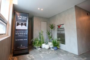a restaurant with plants in the corner of a room at 호텔 마리스테이 태안 in Taean