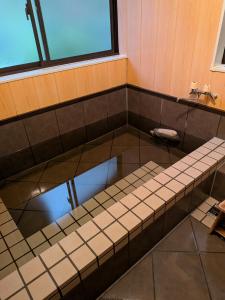 a bath room with a tub with a sink at 信州の古民家宿 真秀ろばmahoroba in Nagano +9 photos
