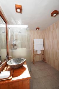 ein Badezimmer mit einem Steinwaschbecken auf der Theke in der Unterkunft Puri Bucuana Villa in Bedahulu + 18 Fotos