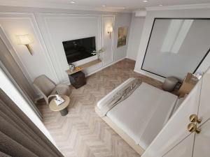 une grande chambre blanche avec une télévision et un lit dans l'établissement Anna Noi Bai Airport Hotel, à Sóc Sơn 6 autres photos