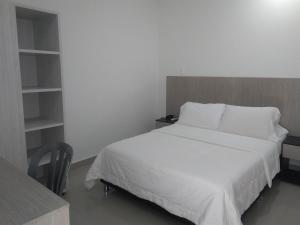 辛塞莱霍Hotel Boutique Santorini Class的卧室里有一张白色的床和一张书桌
