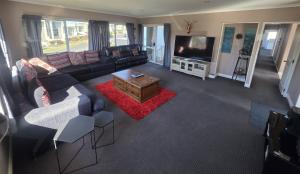 a living room with a couch and a tv at The Retreat Taupo in Taupo