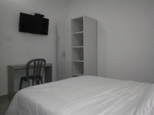 辛塞莱霍Hotel Boutique Santorini Class的一间卧室，配有一张床、一张书桌和一台电视