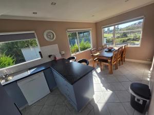 a kitchen and dining room with a table and chairs at The Retreat Taupo in Taupo +5 photos