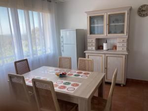 Domaine de la Brugaye Mimosa في Saint-Cézaire-sur-Siagne: مطبخ مع طاولة مع كراسي وثلاجة