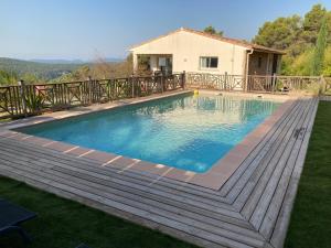 Domaine de la Brugaye Mimosa في Saint-Cézaire-sur-Siagne: مسبح وسطح خشبي ومنزل