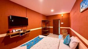 a room with a flat screen tv on a wall at Metro Club Resort in Kāmānayakkanpālaiyam