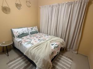 a small bedroom with a bed and a window at Casa Palm and Tide self catering accommodation in Swakopmund