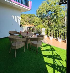 德拉敦Kamlam Homes - Kalagaon Retreat的露台上的草地上摆着桌椅