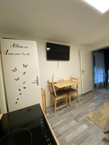 a living room with a table and a tv on the wall at St Georgen im Attergau ein Zimmer Wohnung in Sankt Georgen im Attergau