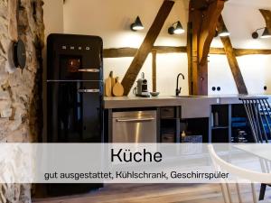 a kitchen with a refrigerator and a table and chairs at N5Quartier in Bad Münstereifel