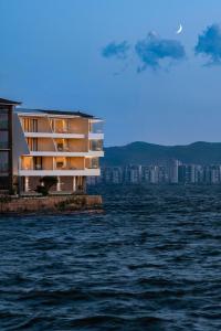 a building on the edge of a body of water at Dali Rushi Jiuxi Sea View Holiday Inn in Dali Airport
