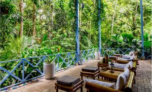 a patio with couches and tables and trees at Hotel Plaza Yara in Manuel Antonio