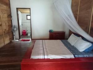 Savana Cottages في Letman: غرفة نوم بسرير مع ناموسية