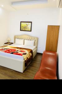 a bedroom with a bed and a chair at Hoàng Gia Hotel Royal in Kim Bảng