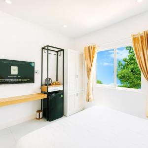 a white room with a window and a television at Hoàng Gia Hotel Royal in Kim Bảng
