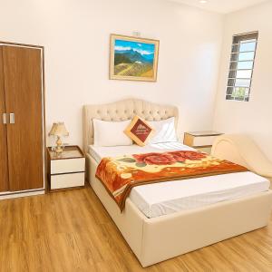 a bedroom with a bed and a night stand at Hoàng Gia Hotel Royal in Kim Bảng