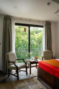 Un dormitorio con una cama y vista a un balcón. en Fox Jaffna by Fox Resorts - Boutique Heritage Luxury, en Jaffna