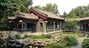 a building with a pond in front of a house at Xana Lite Beijing West Station Branch in Beijing