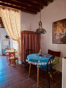a dining room with a blue table and chairs at La Casa del Cine en Níjar in Níjar
