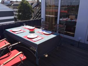 a table on a balcony with glasses and plates at Business Gästehaus Sonne, Mond & Sterne in Bremen