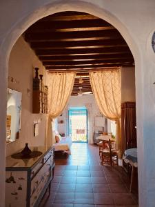 a kitchen with an archway and a room with a table at La Casa del Cine en Níjar in Níjar