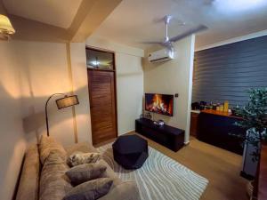 un soggiorno con divano e camino di Cozy stay a Dar es Salaam