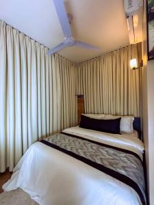 due letti uno accanto all'altro in una stanza con tende di Cozy stay a Dar es Salaam