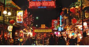 a crowd of people walking down a crowded street at night at Hanoi Fiesta Central Hotel and Spa in Hanoi