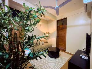 un soggiorno con divano e una grande pianta di Cozy stay a Dar es Salaam